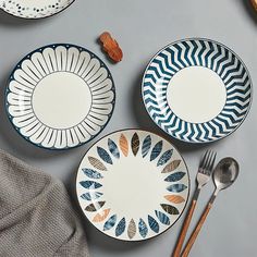 three plates and two spoons on a table