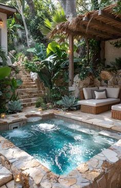 an outdoor hot tub surrounded by greenery and stone steps