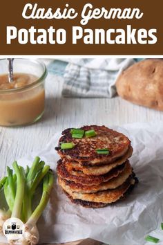 a stack of pancakes sitting on top of a table next to some green onions and sauce