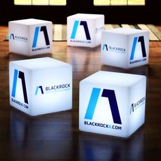 four illuminated cubes sitting on top of a wooden table