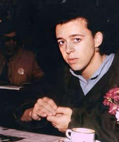 a man sitting at a table with a coffee cup