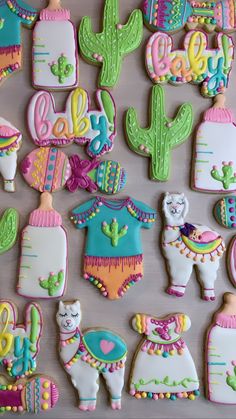 some decorated cookies are sitting on a wooden table with cactuses and llamas