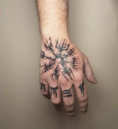 a man's hand with black ink on it and an intricate pattern in the middle