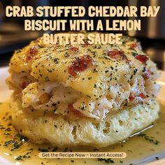 crab stuffed cheddar bay biscuit with a lemon butter sauce on a white plate