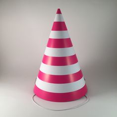 a pink and white striped party hat sitting on top of a table