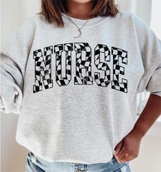 Retro Checkered Nurse Sweatshirt, RN Sweatshirt Nurse Registered Nurse Sweater, Nursing Crewneck, RN Graduation Gift for New Nurse, Er Icu How to Order 1* View all color and size charts before you place your order. 2* Select your shirt "SIZE" and "COLOR". 3* Click add to cart.  If you are ordering more than 1 item, you need to repeat this process for each item you wish to order. Product Information Gildan Hoodie- Sweatshirt 8 oz.(US) 13.3 oz.(CA), 50/50 preshrunk cotton/polyester Heather Sport colors: 60/40 polyester/cotton Air jet yarn = softer feel and reduced pilling Double needle stitching at shoulder, armhole, neck, waistband and cuffs 1 x 1 rib with spandex Quarter-turned to eliminate center crease Safety Green: Compliant with ANSI / ISEA 107 Tearaway label Washing Care Instructors U Nursing Crewneck, Nursing School Outfit, Nursing Student Shirts, Nurse Sweater, Nurse Shirts, New Nurse, Nurse Sweatshirt, Gildan Hoodie, Registered Nurse