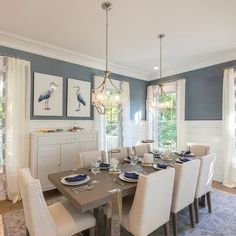 a dining room table with white chairs and blue walls