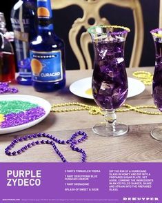 two glasses filled with purple liquid sitting on top of a table