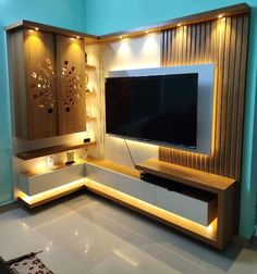 an entertainment center in the corner of a living room with lights on it and a flat screen tv mounted to the wall