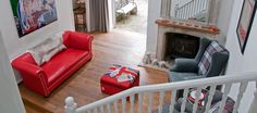 a living room filled with furniture and a fire place next to a stair case in front of a doorway