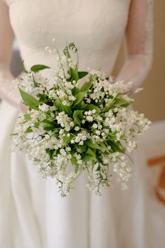 a bride holding a bouquet of white flowers