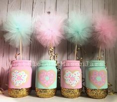 four mason jars with pink, blue and green decorations