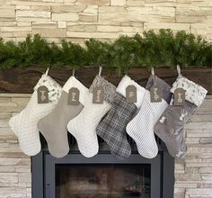 christmas stockings hanging from a mantel in front of a fireplace