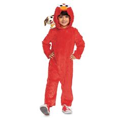 a little boy in a red sesame character costume