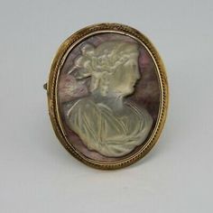 Antique 14K Yellow Gold Mother of Pearl Cameo Pin, White Mother of Pearl with ringlets in hair, looking left against purple background, 1 3/8 inch X 1 inch, rope twist frame decoration, Circa 1940, 6.9 grams Stock # BB266CamPP22 This listing contains photographs of the actual item you will receive. Our items are in excellent condition with little or no signs of wear and many are one of a kind pre-owned estate finds. Please look closely at the pictures in this listing as they are part of the prod Frame Decoration, Rope Twist, Purple Background, Fine Jewelry Designers, Purple Backgrounds, Blue Topaz Ring, Frame Decor, Blue Topaz, Color Me