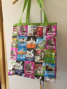 a tote bag hanging from a wall with cat pictures on it