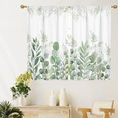 a green and white curtain hanging on the side of a wall next to a wooden dresser