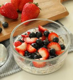 berries and blueberries in a bowl on a cutting board