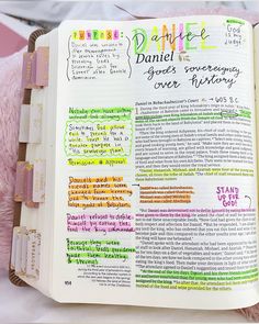 an open bible with colorful writing on the pages and pink teddy bear next to it