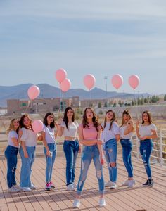 a group of young women standing next to each other on top of a wooden floor