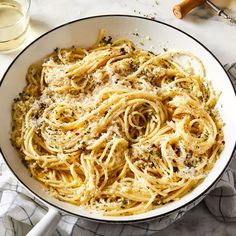 a white bowl filled with pasta and parmesan cheese on top of a table