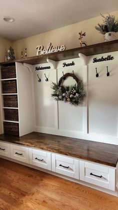 a room with some white cabinets and wooden shelves on the wall next to each other