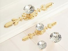 three pieces of jewelry sitting on top of a white counter next to each other,