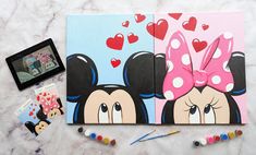 two notebooks with mickey and minnie mouse faces on them, one has a pink bow