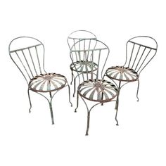 four wrought iron chairs with circular back and foot rests, all in different shapes and sizes