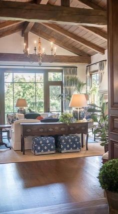 a living room filled with furniture and a chandelier hanging from the rafters