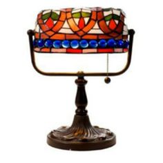 a stained glass cake sitting on top of a metal stand in front of a white background