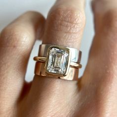 a woman's hand with a gold and white diamond ring on top of her finger