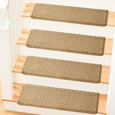 the stair treads are made from wood and have brown dots on them, along with beige carpet