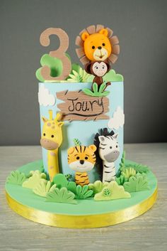 an animal themed birthday cake with the number two on it's top and jungle animals