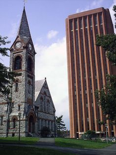 an old church with a steeple next to a tall building