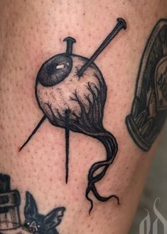 a tattoo on the leg of a person with scissors and an eyeball in it