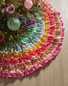 a colorful christmas tree skirt with ornaments on it