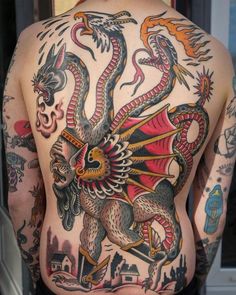 the back of a man's body with tattoos on it, including a dragon