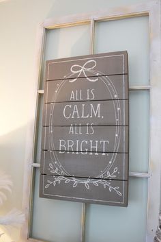 a wooden sign that says all is calm, all is bright on the side of a window