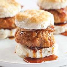 three chicken burgers stacked on top of each other with bbq sauce drizzled on them