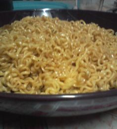 there is noodle noodles in the pan on the stove top, ready to be cooked