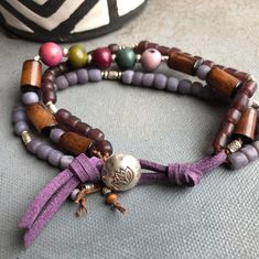 Acai beads in colors of plums and teals with Indonesian glass beads and buri beads with a purple faux suede and hill tribe button closure ⚫Walk on the Wild Side collection: When I first started making jewelry, I fell in love with Tagua nut. I love the shiny bright colors and smooth texture. I also fell in love with Karen Hill Tribe Silver Beads. In this collection each piece is either made from Tagua Nut, Karen Hill Tribe Silver, or both. Your jewelry will come in its own anti-tarnish zip lock b Purple Hand-strung Bohemian Bracelet, Bohemian Bracelets With Purple Round Beads, Handmade Purple Bohemian Beaded Bracelets, Bohemian Purple Beaded Bracelets For Jewelry Making, Bohemian Purple Beaded Bracelets Hand Wrapped, Bohemian Purple Hand Wrapped Beaded Bracelets, Purple Bohemian Hand Wrapped Beaded Bracelets, Handmade Purple Multi-strand Bracelets, Handmade Purple Multi-strand Bracelet