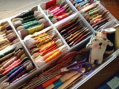 several bins filled with different colored thread and scissors