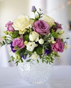 a vase filled with lots of purple and white flowers