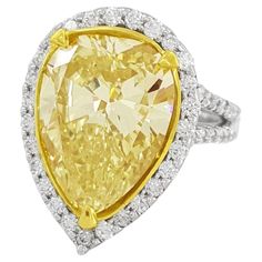 a fancy yellow diamond ring set in 18k white gold with diamonds around the band