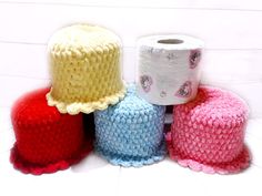 four crocheted hats sitting next to each other on top of a white floor