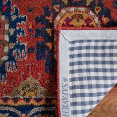 an area rug is laying on the floor next to a piece of wood that has been placed in front of it