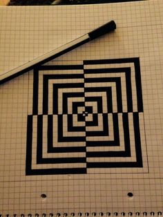 a pen sitting on top of a piece of paper next to a spiral maze design