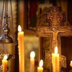 candles are lit in front of a crucifix