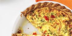 the quiche is ready to be eaten on the white plate with an orange napkin